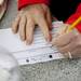Someone fills out a voting form at Sukkah Arbor at Liberty Plaza Park on Sunday. Daniel Brenner I AnnArbor.com